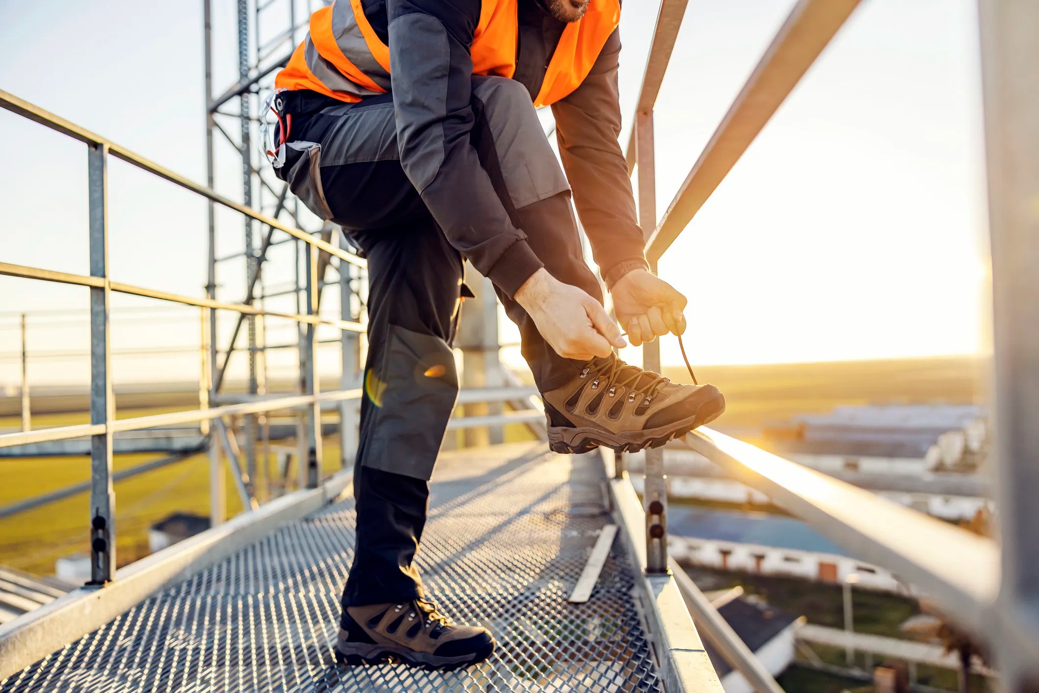 Worker wearing ASTM F2413-24 safety toe footwear on a construction site, demonstrating protective industrial footwear features.