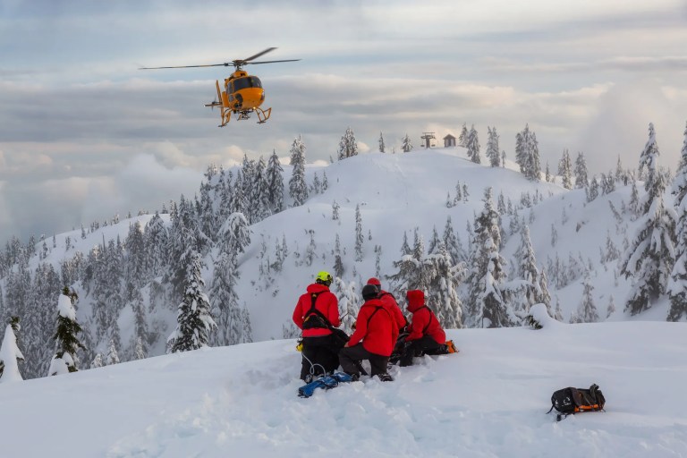 Ground search and rescue (GSAR) team conducting wilderness search in Canada under CSA Z1620-2024 national competency standard finding missing person on a snowy mountain.