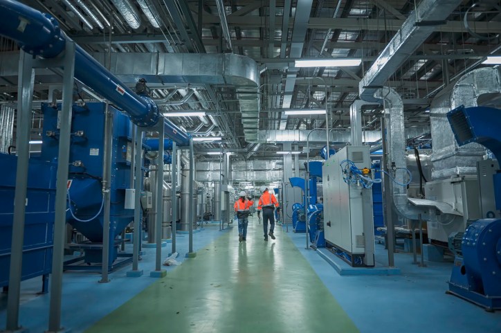 Two workers conducting an ISO/IEC 17020:2026 inspection in blue petrochemical plant.