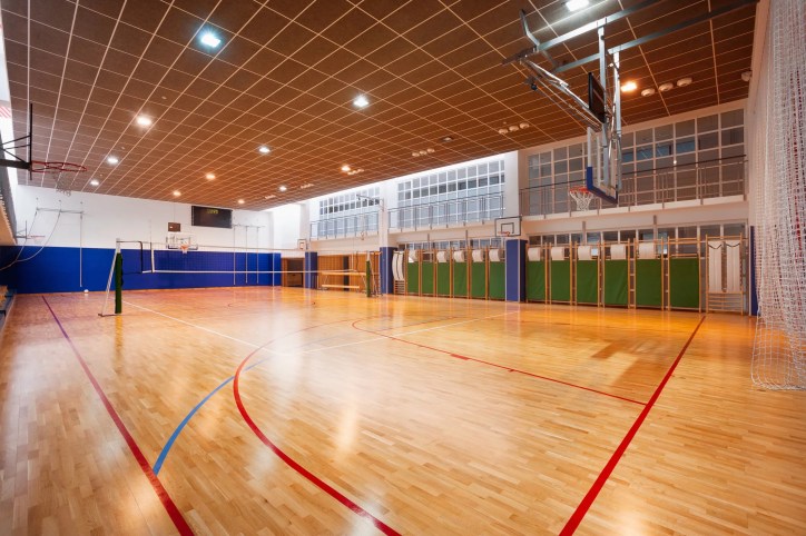 Sports floor in a gymnasium for basketball or volleyball, adhering to ASTM F2772-24 guidelines, assuring safety, shock absorption, and optimal athletic performance.