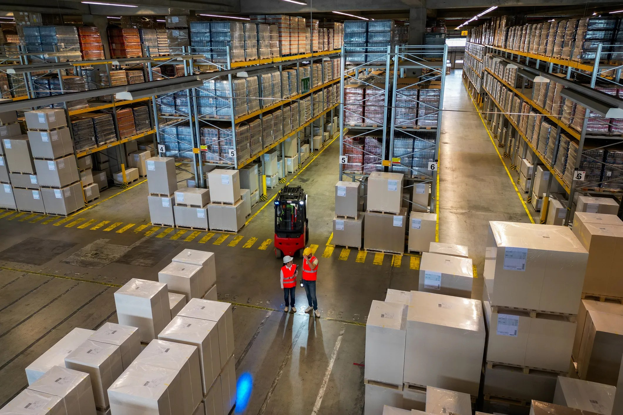 Warehouse full of boxes with orange forklift
