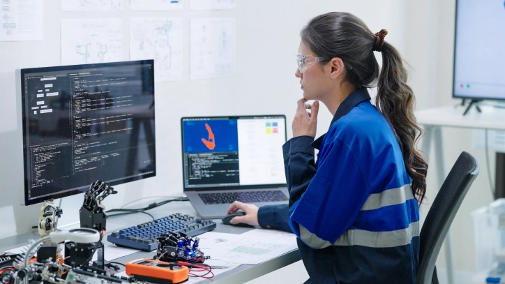 Software engineer working on code for cybersecurity protection for machine learning medical devices like a prosthetic arm connected to hospital networks, highlighting data security and patient safety, underscoring the importance of adhering to AAMI CR515:2025.