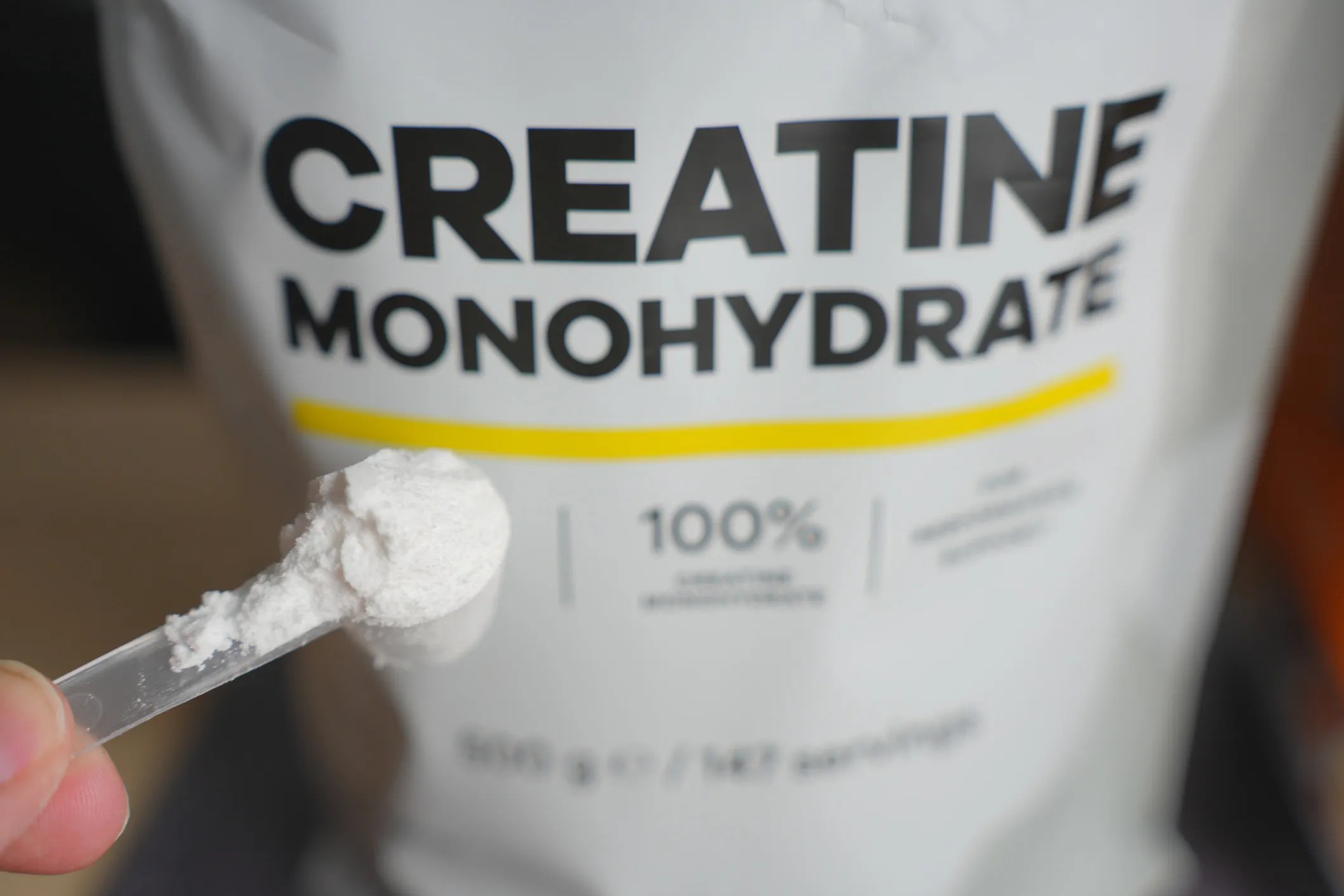 Athlete taking creatine dietary supplement, adhering to ISO 17034 and ISO/IEC 17025 testing, to help with muscle recovery and brain health.
