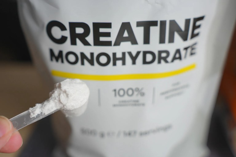 Athlete taking creatine dietary supplement, adhering to ISO 17034 and ISO/IEC 17025 testing, to help with muscle recovery and brain health.