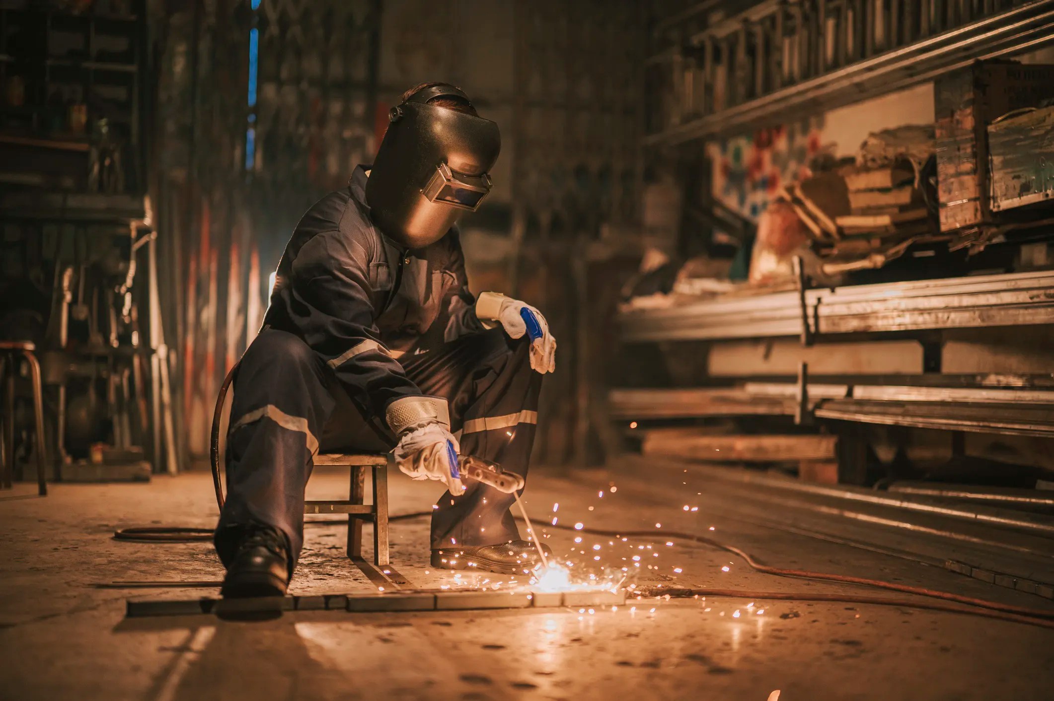 Traditional blacksmith heating metal in a forge and hammering steel during the early forge welding process