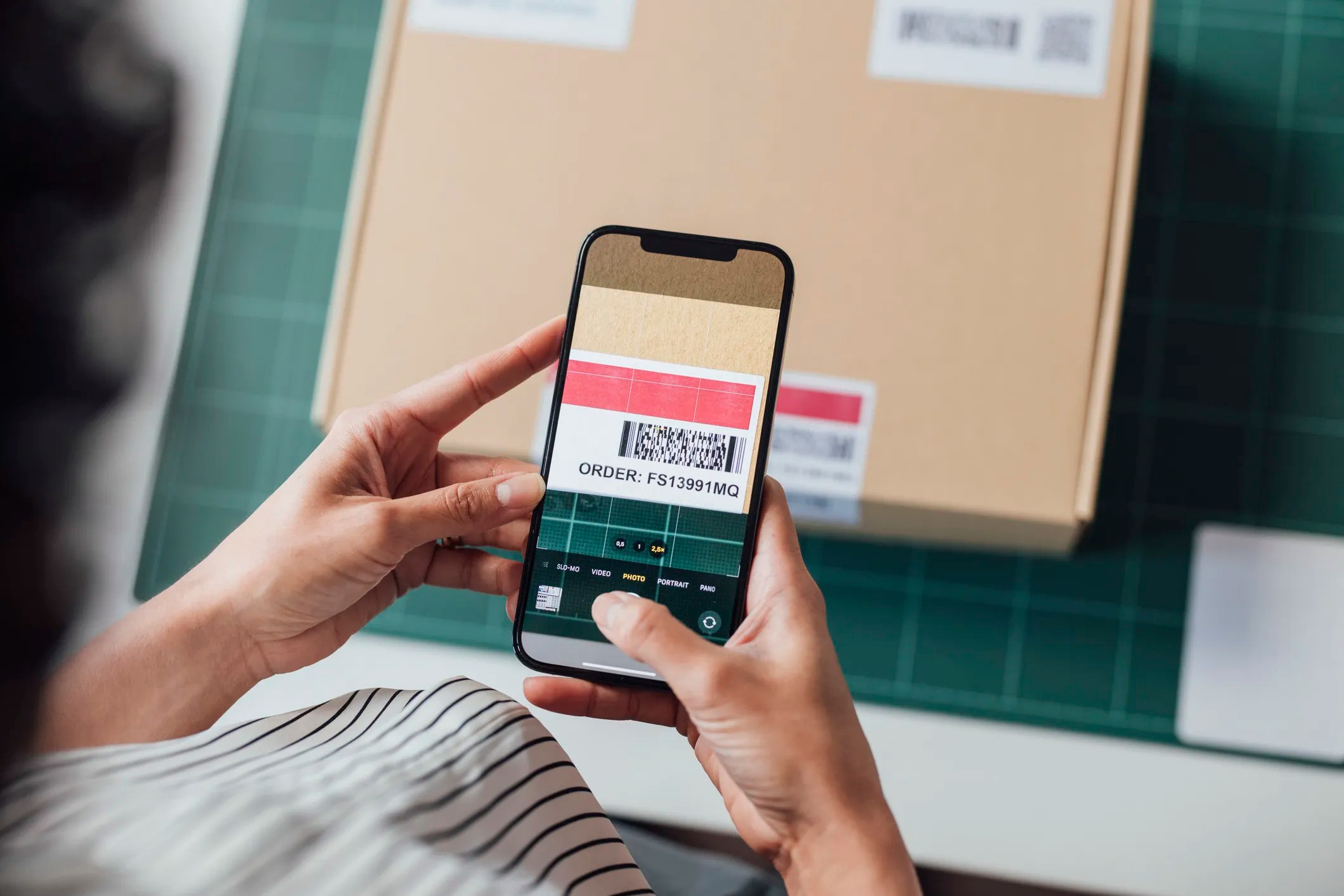 Customer making a retail return by scanning the barcode, which adheres to ISO/IEC 15416:2025, on her phone.