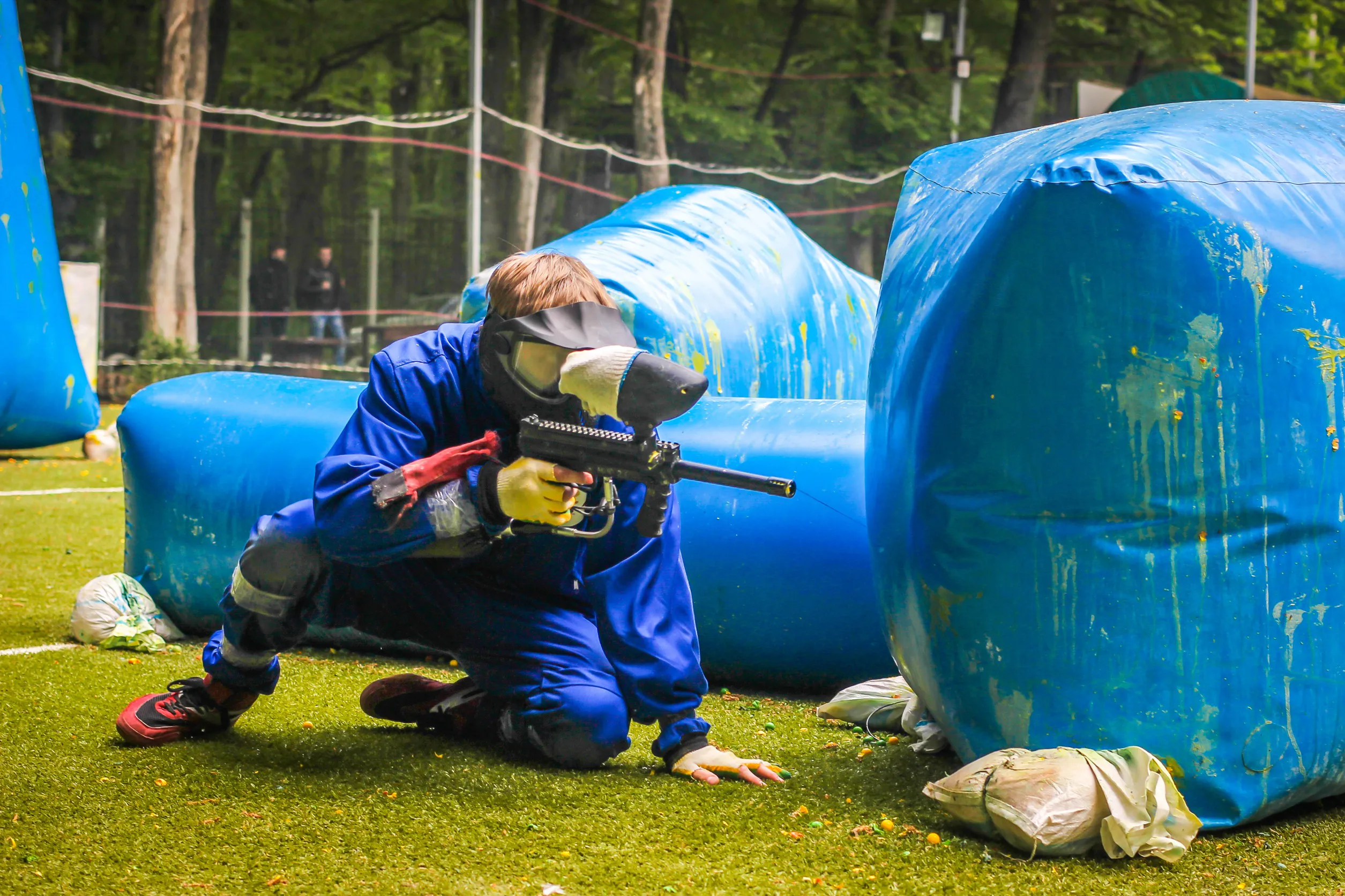Paintball player wearing protective masks receiving a safety briefing that adheres to ASTM F2801-19(2023) before a game on a regulated field.