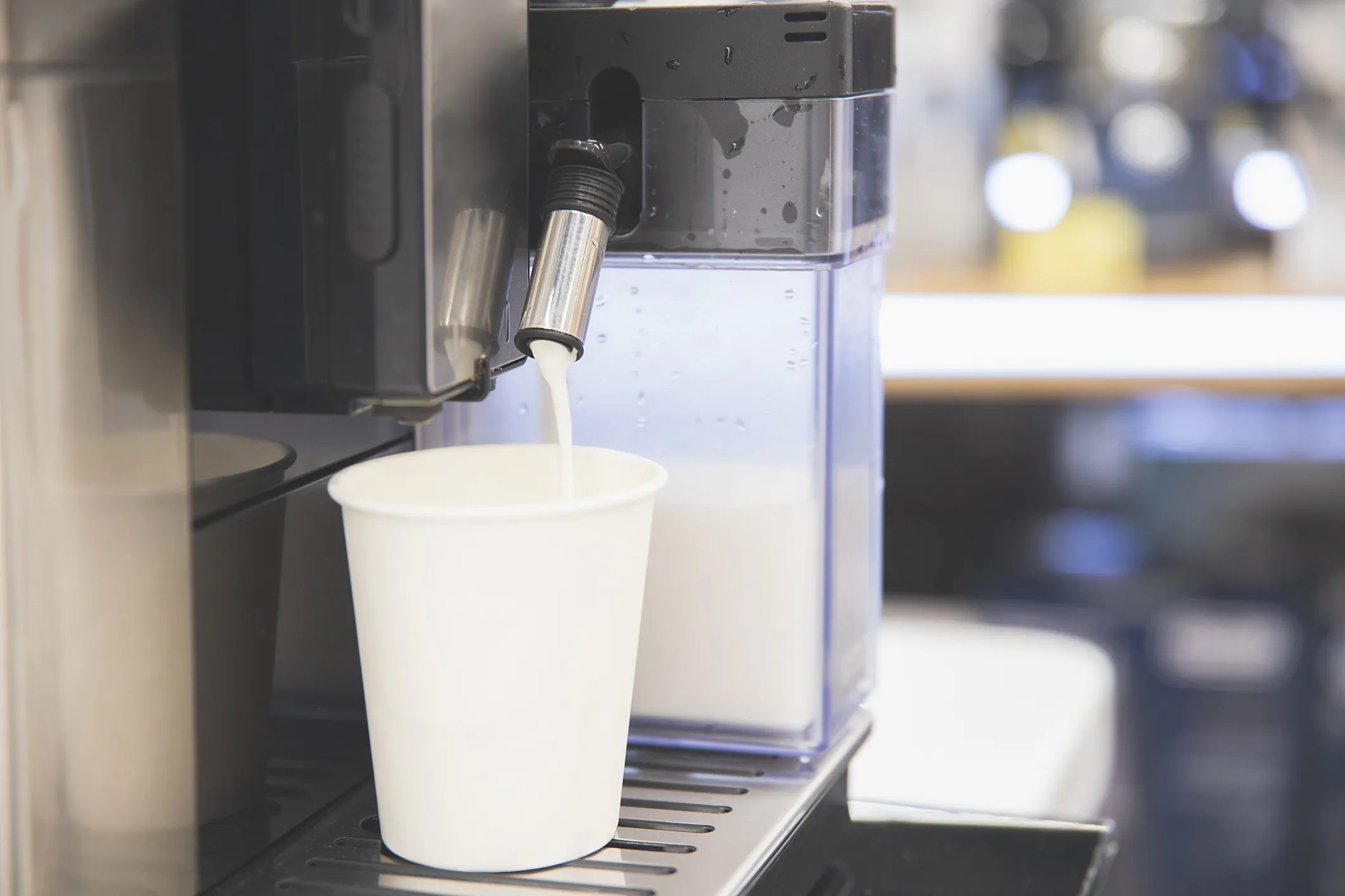 Commercial bulk milk dispensing equipment in a cafeteria setting, demonstrating hygienic, temperature-controlled dairy service compliant with NSF/ANSI 20-2023.