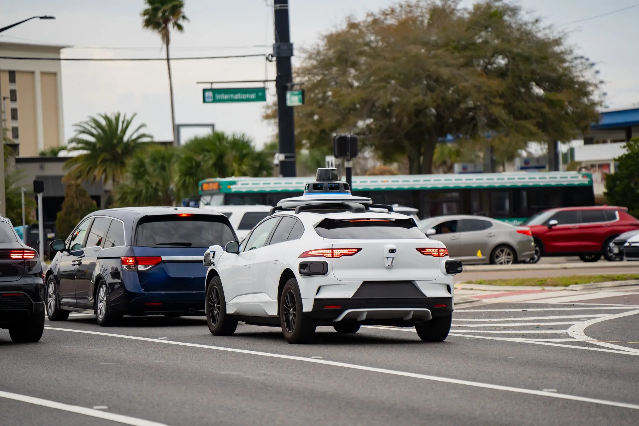 Self-driving car operating autonomously on a modern city street using artificial intelligence, sensors, and camera systems for navigation and obstacle detection.
