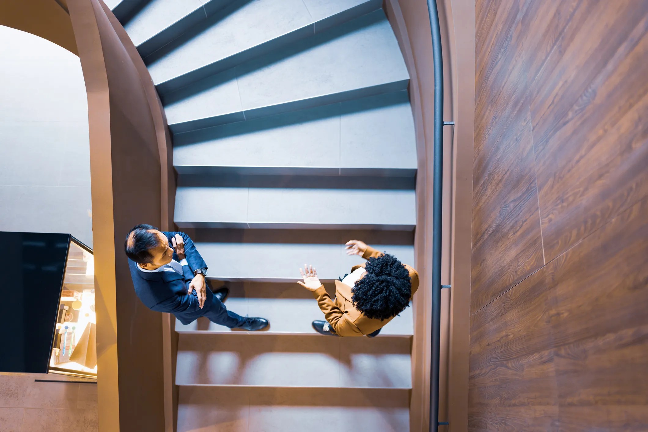 Aerial view of people in stairs talking about bridging data gap between them.