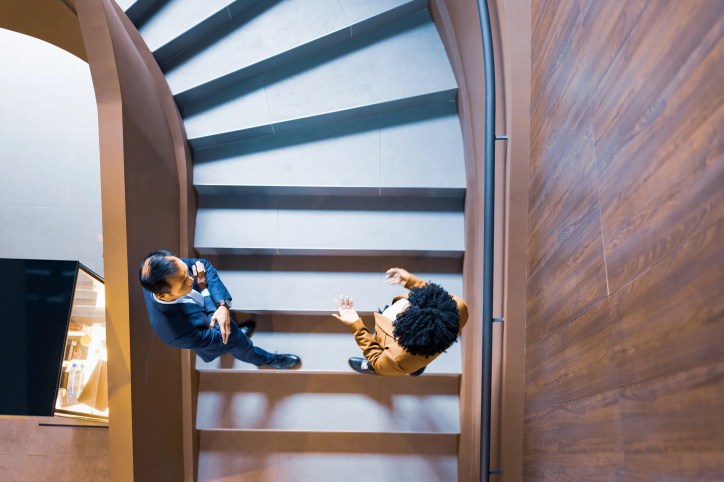 Aerial view of people in stairs talking about bridging data gap between them.