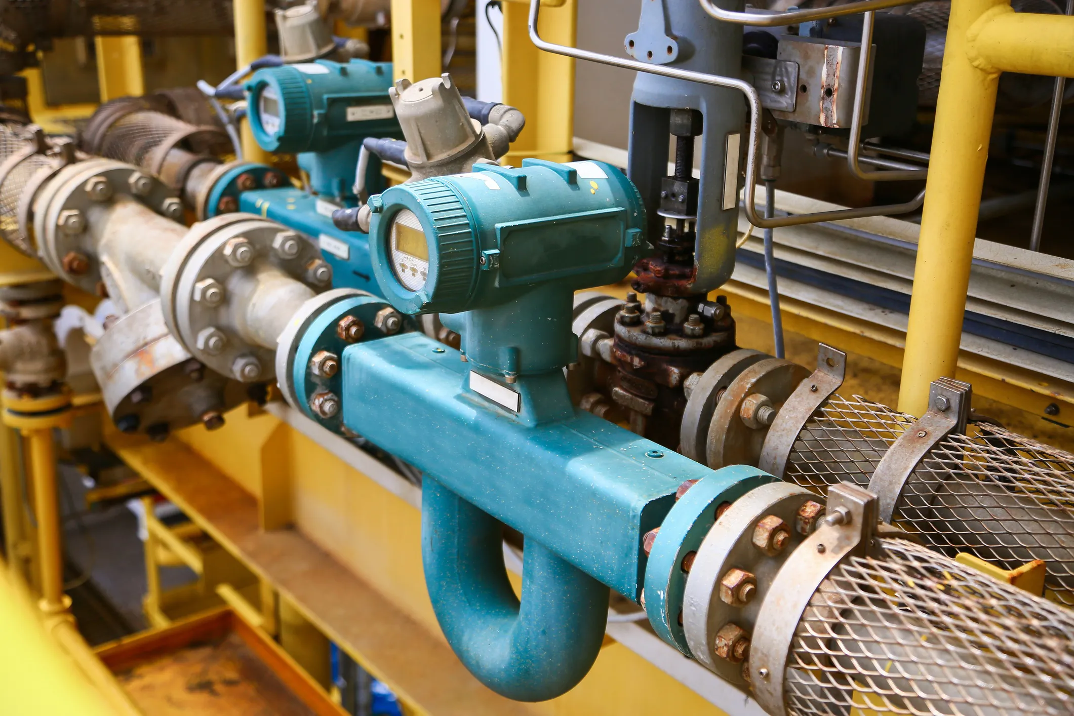 Natural gas pipeline technician inspecting an industrial orifice metering station, adhering to AGA XQ1601, used for accurate hydrocarbon flow measurement and custody transfer operations..