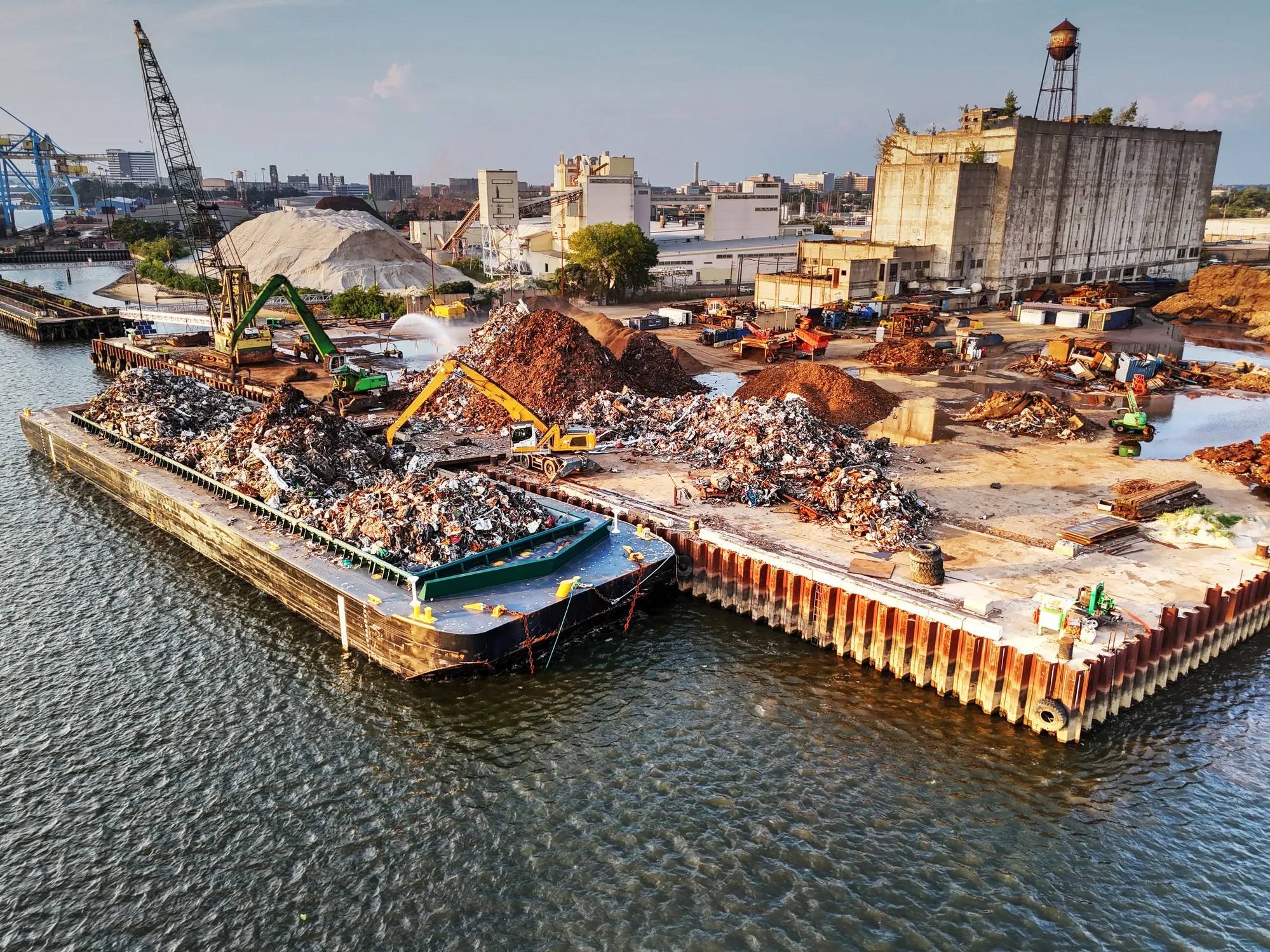 Commercial cargo ships docked at a modern seaport with waste reception infrastructure supporting marine environmental protection under ISO 16304:2018.