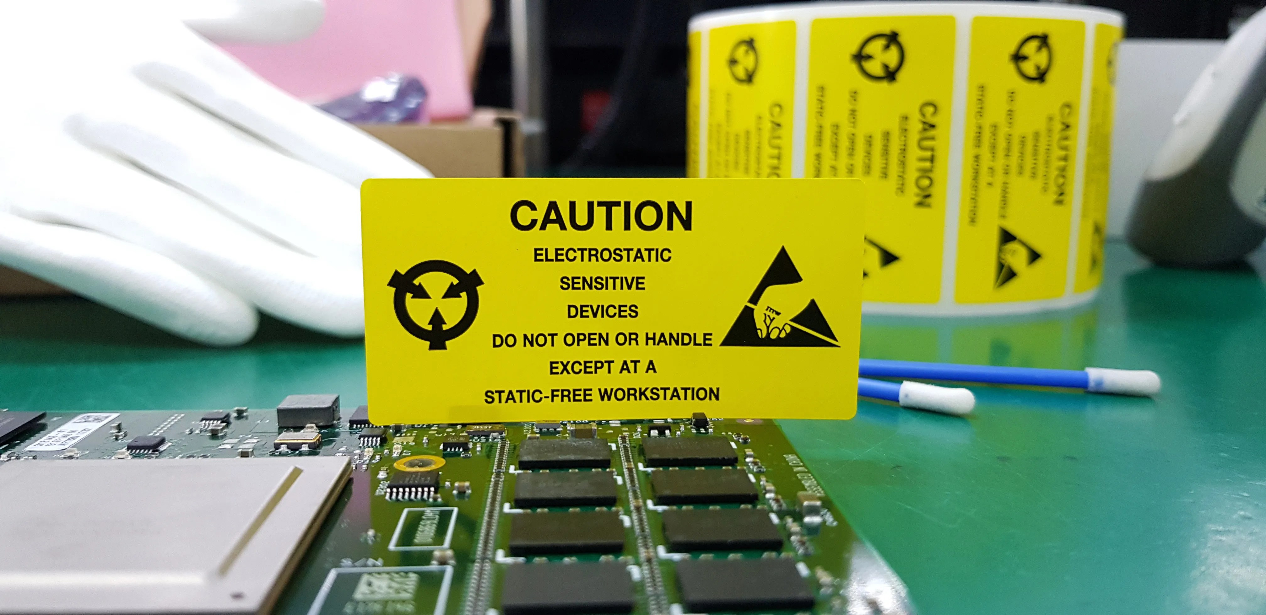 The yellow CAUTION label for Electrostatic Sensitive Devices (ESD) on static free workstation.
