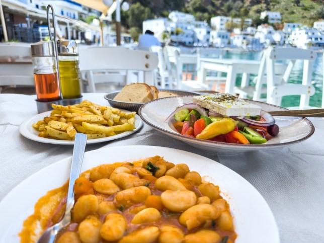 Traditional greek food: Giant beans in tomato sauce with fried potatoes and Greek salad, showing the healthy European (Mediterranean) diet.