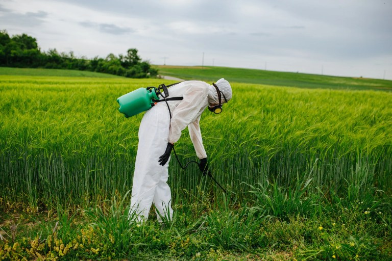 Agricultural worker wearing PPE that was tested for liquid pesticide repellency, retention, and penetration under ISO 22608:2021 laboratory conditions.