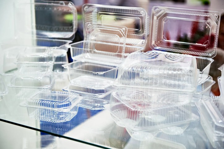 Close-up of compostable plastic food containers, utensils, and packaging made from plant-based materials adhering to ASTM D6400-23.