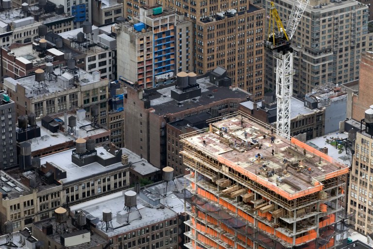 Engineers on top of a building with scaffolding inspecting a high-rise building structure in NYC to evaluate safety, structural integrity, and compliance with building safety standards.