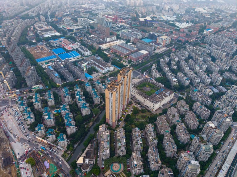 A modern city overlaid with GIS mapping technology, adhering to ISO 19115-1:2014, showing roads, buildings, utilities, and real-time geographic data.