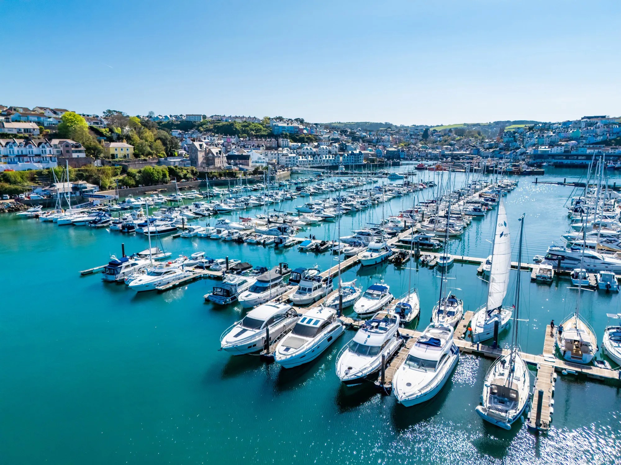 Luxury superyachts docked at a modern marina illustrating ISO 21406:2020 requirements for luxury yacht harbors and premium marina services.