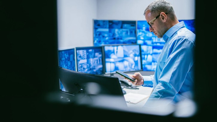 A cybersecurity professional reviewing digital security data representing ISO/IEC 27000:2026 and information security management systems (ISMS).