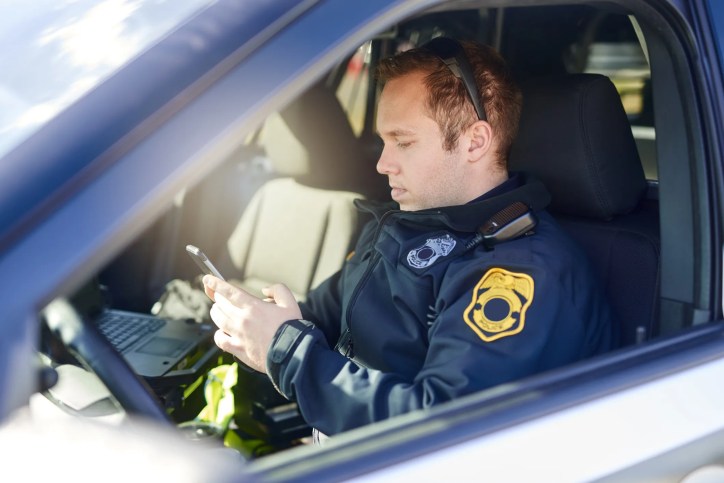 Public safety personnel using Push-to-Talk over Cellular (PoC) devices over a 5G network (that adheres to ATIS-0700016), representing secure IMS communications and lawful electronic surveillance capabilities.