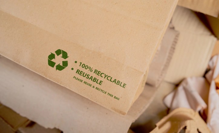 Product packaging displaying environmental claims such as recyclable and reusable alongside sustainability icons representing adherence to ISO 14021:2026.