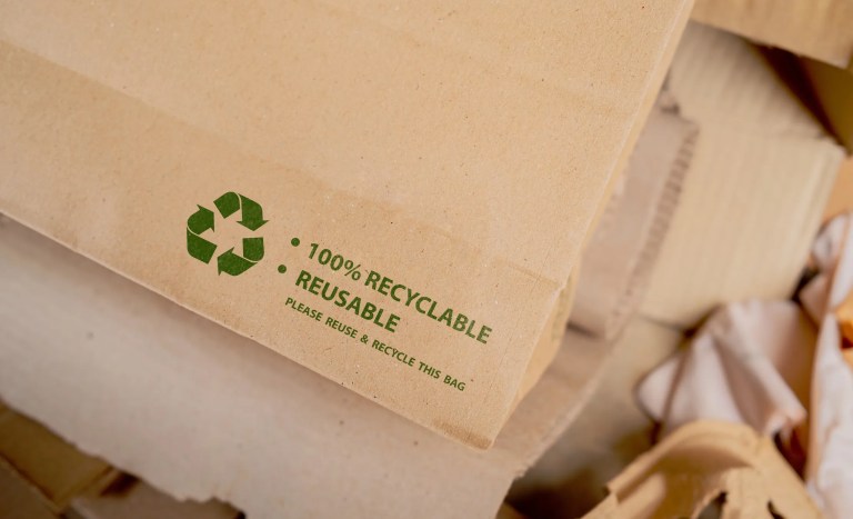 Product packaging displaying environmental claims such as recyclable and reusable alongside sustainability icons representing adherence to ISO 14021:2026.