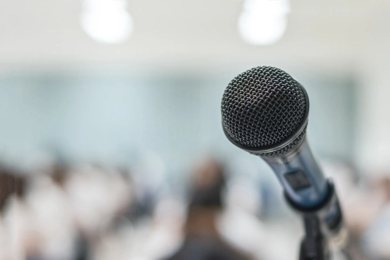 Loudspeakers in an auditorium illustrating how ANSI/AVIXA A102.01:2023 measures and classifies audio coverage uniformity across listener areas.