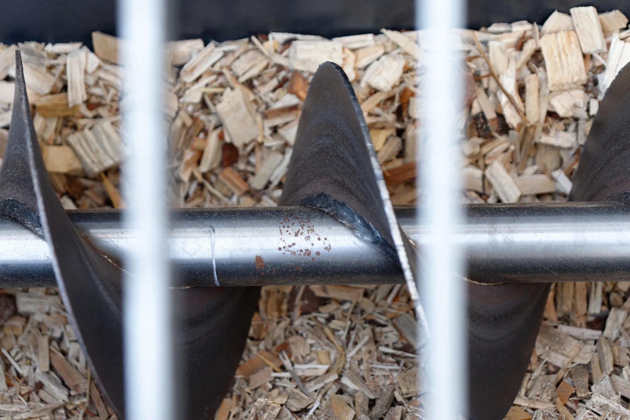 Industrial screw conveyor, adhering to ANSI/CEMA 350-2021, transporting bulk materials.