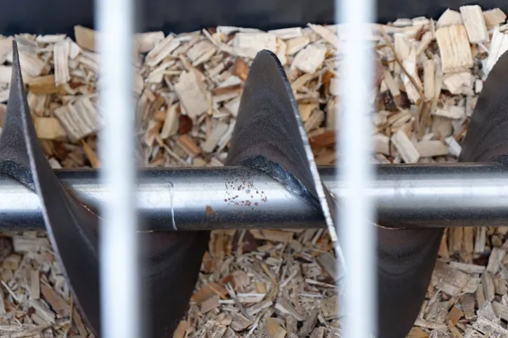 Industrial screw conveyor, adhering to ANSI/CEMA 350-2021, transporting bulk materials.