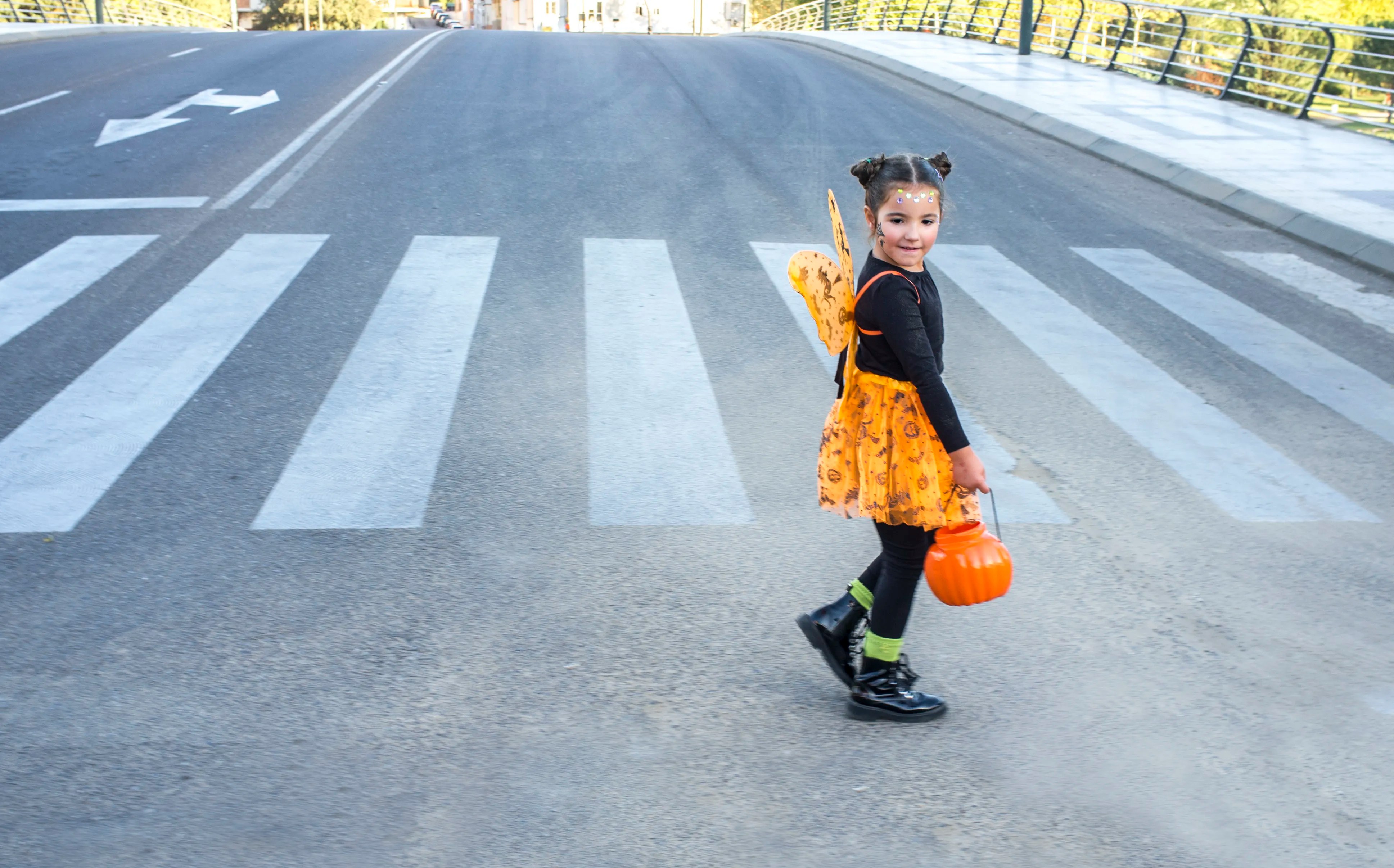 A Halloween trick-or-treater wearing a costume with reflective details, illustrating visibility principles from ANSI/ISEA 107-2020 for pedestrians after dark.