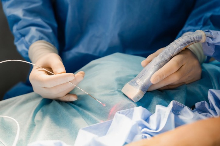 Perioperative nurses using surgical laser equipment, adhering to AORN MAN-896-2020, in an operating room while following laser safety precautions.