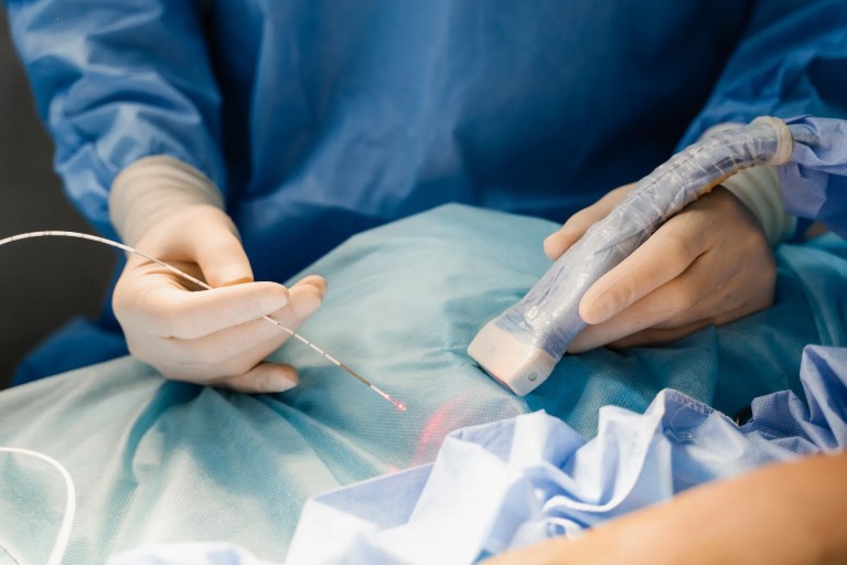 Perioperative nurses using surgical laser equipment, adhering to AORN MAN-896-2020, in an operating room while following laser safety precautions.