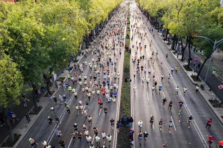 Marathon runners participating in a road race with other runners and spectators, illustrating how ISO 20121:2024 can support more sustainable marathon event planning and operations.