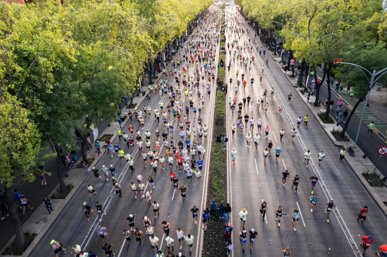 Marathon runners participating in a road race with other runners and spectators, illustrating how ISO 20121:2024 can support more sustainable marathon event planning and operations.